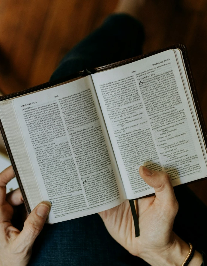 a person holding an open book in their hands